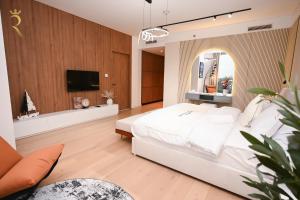 阿布扎比Sandy 1BR Soul Beach Mamsha Al Saadiyat Island的卧室配有白色的床和平面电视。