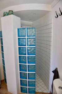 卡拉瓦德亚apartment with magnificient Es Vedra view的浴室设有蓝色玻璃架和淋浴