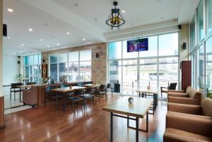 芭堤雅市中心Adelphi Pattaya - SHA Extra Plus的一间带桌椅的餐厅和一间酒吧