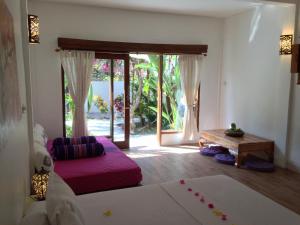 吉利特拉旺安鲁玛卡哈亚旅馆的一间带床和大玻璃门的客厅