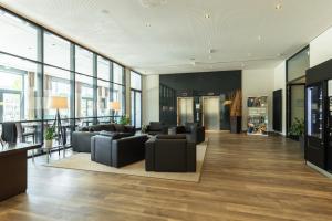 德累斯顿德累斯顿城际酒店的办公室大堂设有黑色家具和大窗户