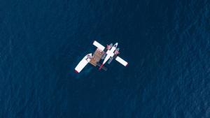鲁阿环礁The Standard, Huruvalhi Maldives的一架小飞机飞越蓝色的水面