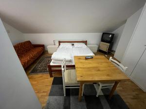 布尔泽策Apartments and Rooms Vicko的一间卧室配有一张床、一张桌子和一张沙发