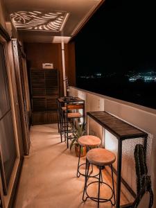 本部オーシャンテラス瀬底 Room403的夜晚阳台上的一排桌子和凳子