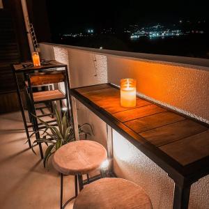 本部オーシャンテラス瀬底 Room403的阳台设有酒吧,提供蜡烛和凳子