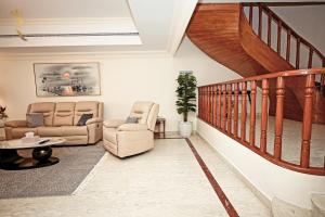 阿布扎比Beach bliss 3BR apartment Corniche的一间带两把椅子和楼梯的客厅
