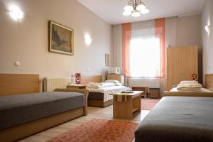 马泰绍尔考Korona Panzió的酒店客房设有两张床和窗户。