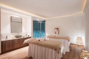 圣特雷莎加卢拉Mangia's Santa Teresa Sardinia, Curio Collection by Hilton的客房设有两张床、一个水槽和镜子