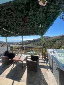 IznateCasa Rural Málaga Monkey Love con jacuzzi的一个带桌椅的庭院和一个游泳池
