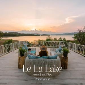 班康卡臣Le La Lake Resort and Spa的坐在甲板上观看日落的女人