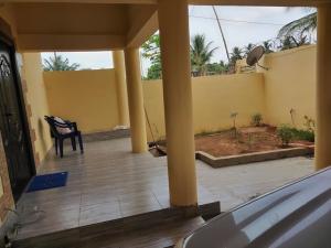 villa privée avec garage privé à Lomé Togo的一个带黑椅子和黄色墙壁的门廊