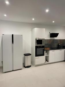 LancransVilla Lancrans的厨房配有白色橱柜、炉灶和冰箱。