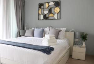 邦涛海滩Cassia Residences by NLA的一间卧室配有白色床和蓝色枕头