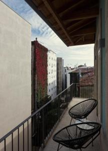 波尔图Laranjais Boutique Suites & Apartments Porto的两把椅子坐在大楼的阳台上