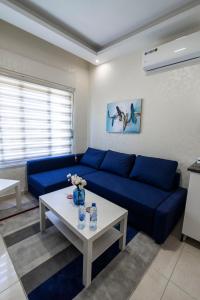 Ţāb Kirā‘Amman Sun Apartments的客厅配有蓝色的沙发和桌子