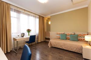 索非亚吉尼瓦酒店的配有一张床、一张书桌和一扇窗户的酒店客房