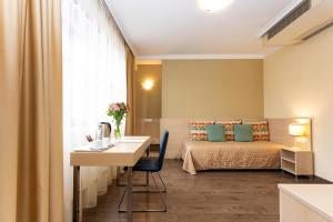 索非亚吉尼瓦酒店的客房设有一张床、一张桌子和一张书桌。