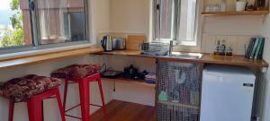 AlonnahKaoru on Bruny的厨房配有柜台和2张红色凳子