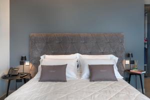 切法卢Emerald Hotel Residence Cefalù的一间卧室配有一张大床和两个枕头