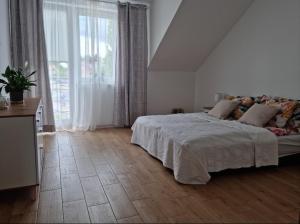 什奇特诺Apartament Szczytno - Centrum的白色的卧室设有床和大窗户