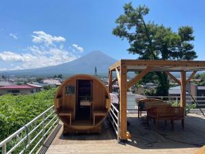 富士河口湖Mount Fuji Panorama Glamping的甲板上设有1间带桌椅的桑拿浴室