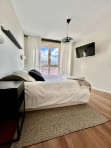 马德里Moderno apartamento inteligente的白色的卧室设有一张大床和一个窗户