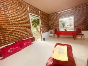 Homestay Bách Thảo Tà Lùng的一间卧室设有一张床和砖墙