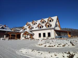 斯托尼拉斯奇Miodówka的一座白色的大房子,有雪盖屋顶