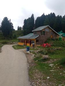 古尔马尔格Gulmarg View Cottage的土路旁的小建筑