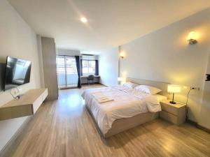 曼谷Pipp Residence的一间卧室配有一张大床和电视