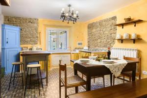 维迪奇亚蒂科Suite il Corno的厨房配有桌椅和石墙