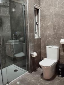 斯利马Pearl Apartments的一间带卫生间和玻璃淋浴间的浴室