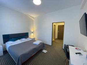 雅西阿斯托利亚市中心酒店的酒店客房,配有床和电视
