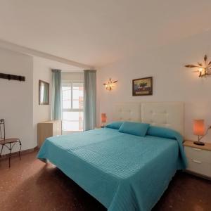 托雷德尔马尔泰拉索普拉扎玛尔公寓酒店的一间卧室配有一张带蓝色棉被的大床