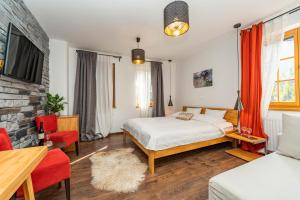 普利特维采湖B&B Villa Sumrak Plitvica Rooms的一间卧室配有一张床、一张沙发和一台电视。