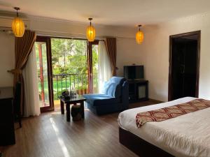 萨帕沙坝精英酒店的一间带一张床和一把椅子的卧室以及一个阳台