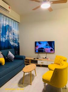 哥打京那巴鲁JQ Citypads by Golden Stay的客厅配有蓝色的沙发和黄色的椅子