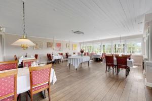 Jelling瑟夫戴尔库洛酒店的一间设有白色桌椅和窗户的用餐室