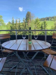 申瓦尔德Schöne Maisonette-Ferienwohnung für 2-5 Personen的一张带两杯酒和一瓶葡萄酒的木桌