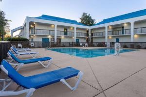 杰克逊维尔杰克逊维尔/勒琼营贝蒙特旅馆套房酒店的一个带游泳池和蓝色躺椅的度假胜地