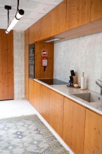 ArcozeloFisherman's Blues - Casa na Praia的一个带木制橱柜和水槽的厨房