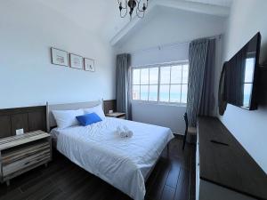 潘切Seamoni Seaview Villa 02 - Novaworld Phan Thiết的一间卧室配有一张床和一台电视