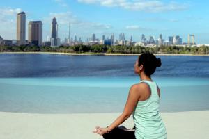 迪拜迪拜柏悦酒店的坐在海滩上看着城市的女人