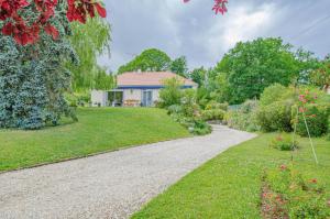Vendeuvre-sur-BarseLa maison vautier的一个带房子和碎石车道的花园