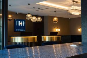 惠灵顿TRYP by Wyndham Wellington, Tory Street的酒吧配有桌椅和笔记本电脑