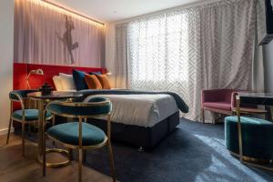 惠灵顿TRYP by Wyndham Wellington, Tory Street的酒店客房带一张床、一张桌子和椅子