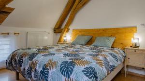 Le gite du cerf的一间卧室配有一张带蓝色和白色棉被的床