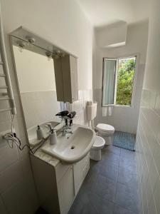 因佩里亚Right Bank House的白色的浴室设有水槽和卫生间。