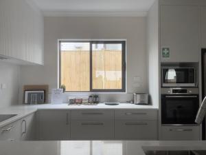 奥克兰Murphys Guest Home的厨房配有白色的柜台和窗户。