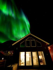 莱克内斯Rorbu Skreda的上面有绿色的北极光的房子